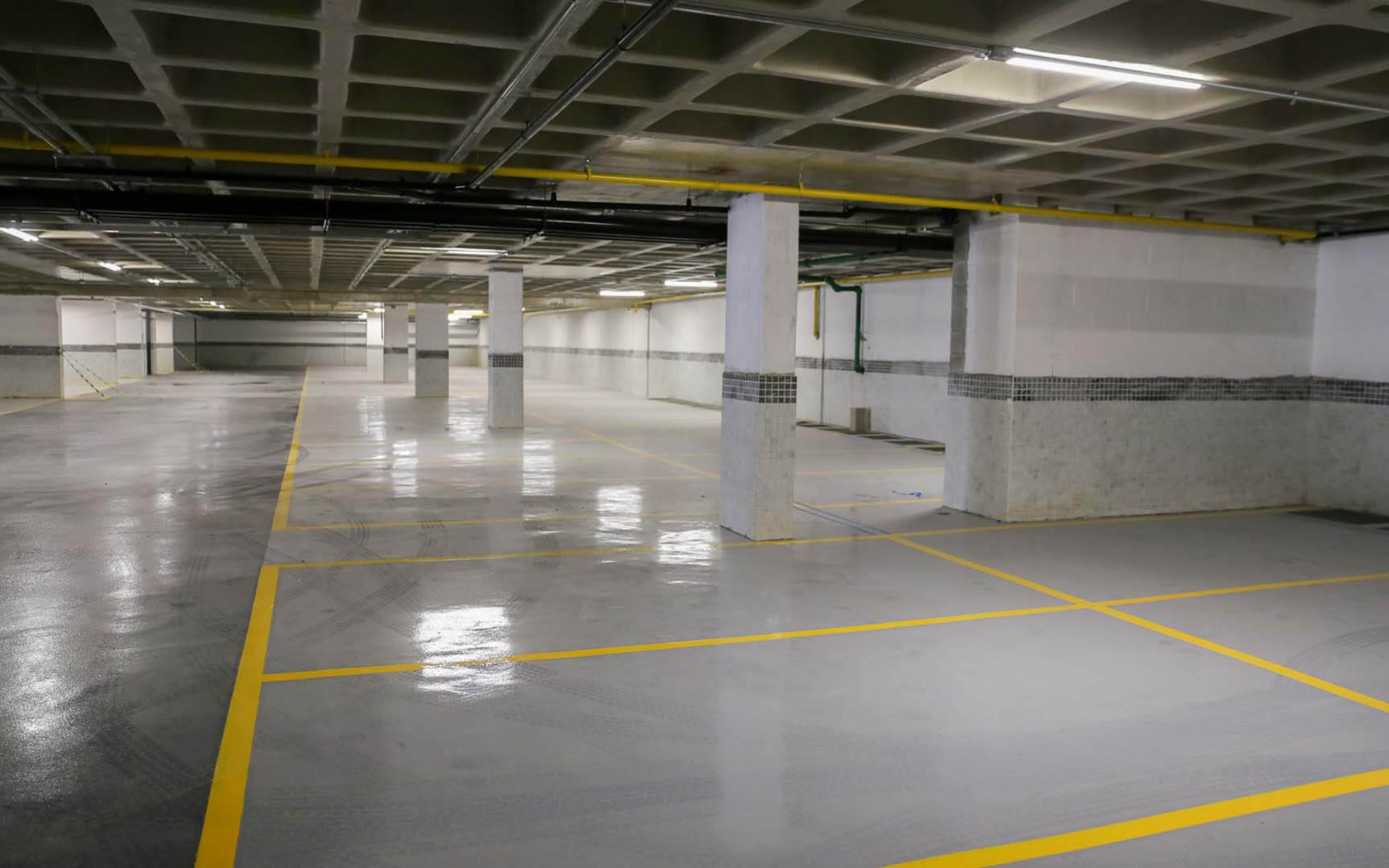 Garagem com piso em pintura epóxi, revestimento cerâmico em meia altura