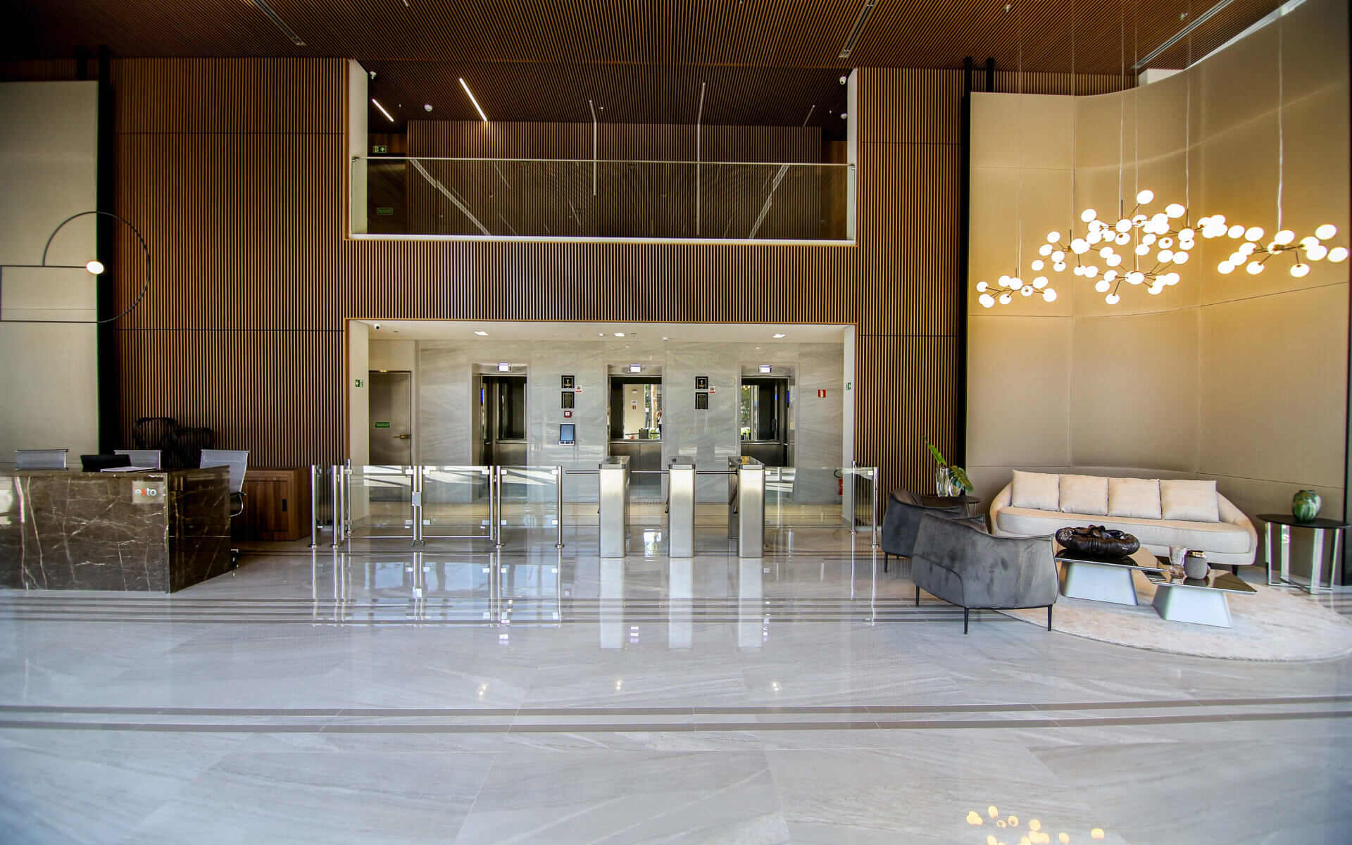 Lobby com pé direito duplo e fachada com detalhes em “pele de vidro”