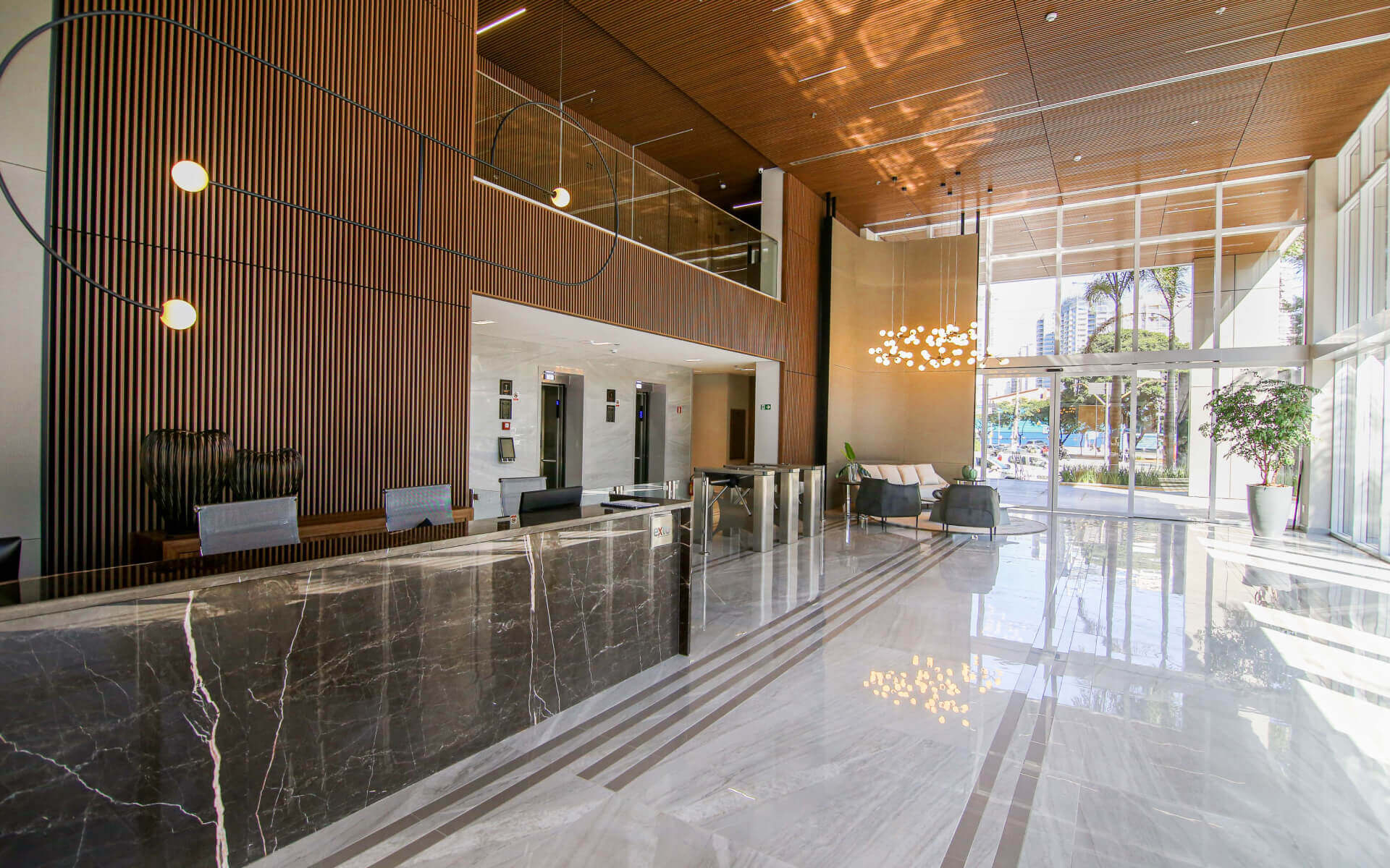 Lobby com pé direito duplo e fachada com detalhes em “pele de vidro”