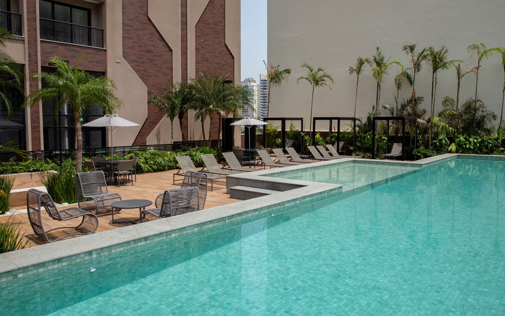 Piscina climatizada de 20 metros com borda infinita e deck molhado