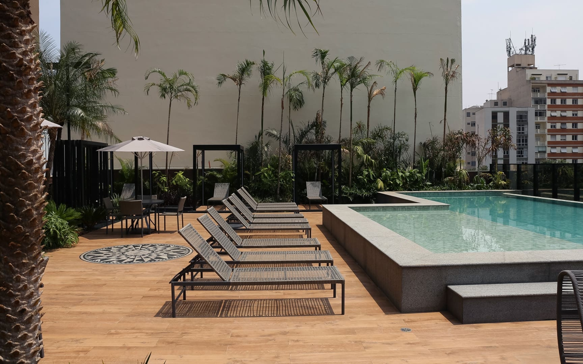 Piscina climatizada de 20 metros com borda infinita e deck molhado