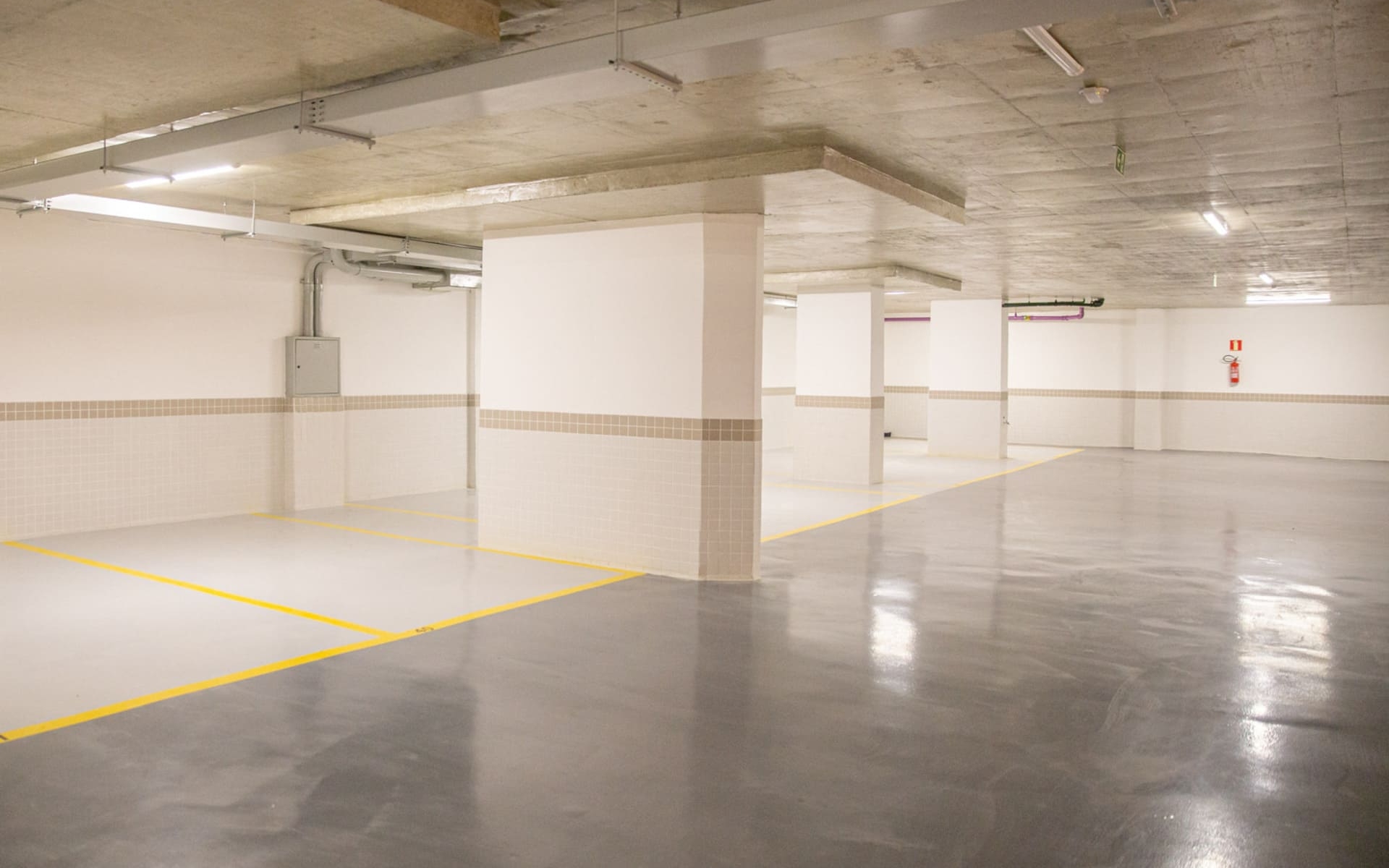 Garagem em padrão diferenciado, com piso em pintura epóxi e barrado em revestimento cerâmico
